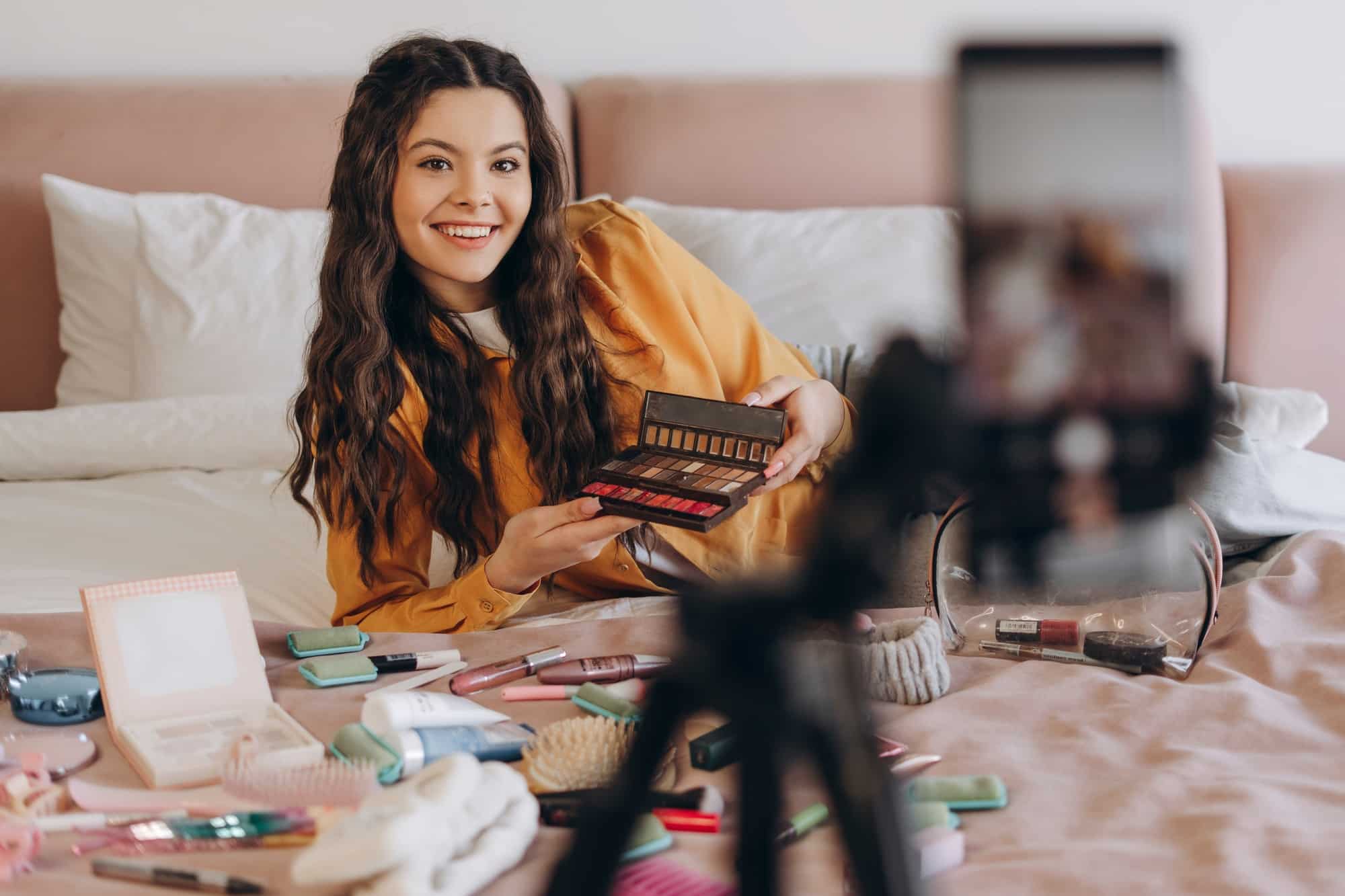 Beautiful influencer testing beauty product content marketing strategy and smiling while making social media video