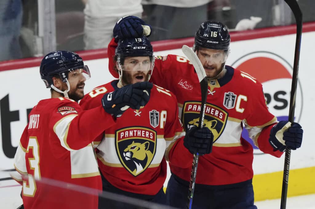 Florida Panthers hockey players celebrate a goal on the ice during a game.