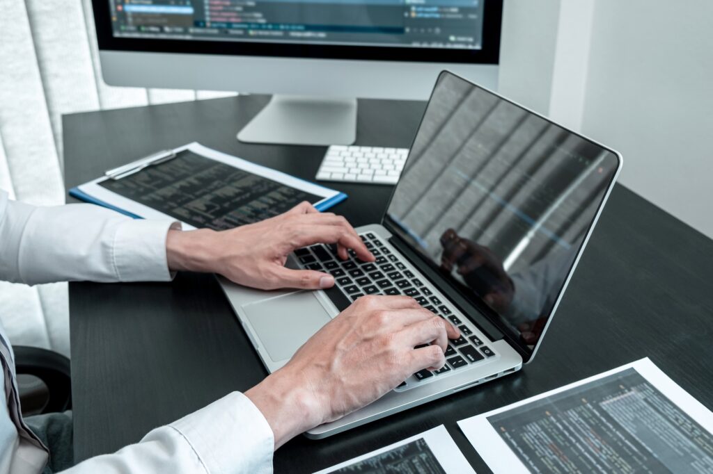 Programmer working in software javascript computer in IT office, Writing codes and data code